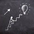 Ein Strichmännchen läuft ein Treppe zu einer Glühbirne hoch