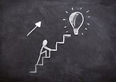 Ein Strichmännchen läuft ein Treppe zu einer Glühbirne hoch