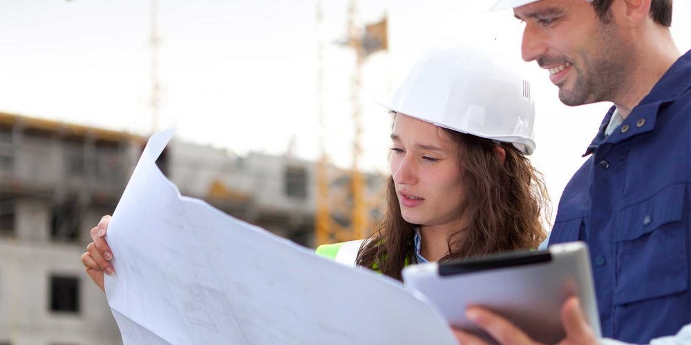 Eine Frau und Ein Mann sehen sich einen Plan näher an